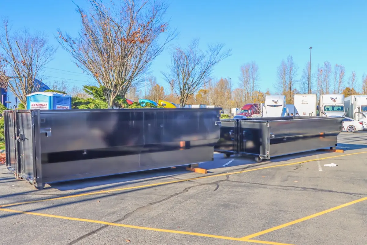 Professional dumpster rental service with roll-off container on residential driveway in Sheridan